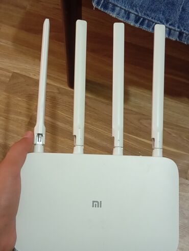 Kompüter və noutbuk aksesuarları: Dörd xarici antenası olan bu ağ rəngli Xiaomi Wi-Fi routeri.Elaqe