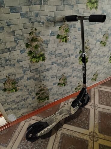 купить трюковой самокат в баку: Gümüşü rəngli, qara tutacaqlı skuter. Ayaq qoyulan hissəsində maraqlı