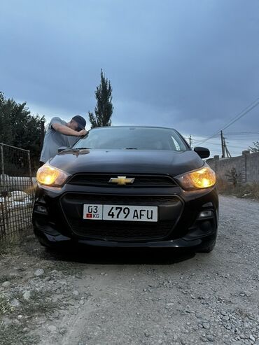 ретро авто: Черный автомобиль Chevrolet с включенными фарами, освещающими путь. На