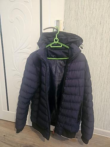 Kişi geyimləri: Tünd göy rəngdə yüngül puffer üslubunda qışlıq/jelletli gödəkcə. - — 2