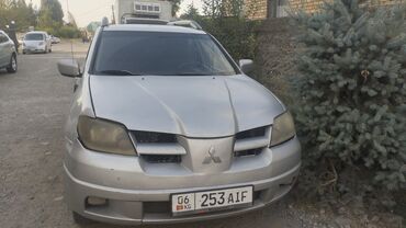 прадажа афто: Серебристый внедорожник Mitsubishi Outlander, оснащенный багажником на