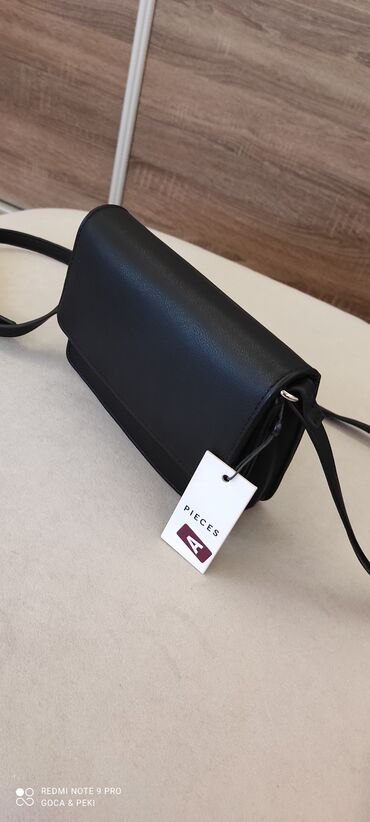 Torbe: PIECES nova crna torbica sa etiketom, dugačak podesivi kaiš. 20cm X