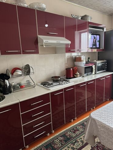 Кухонные шкафы: Гарнитур кухонный с фасадами цвета бордо и белой столешницей. Включает