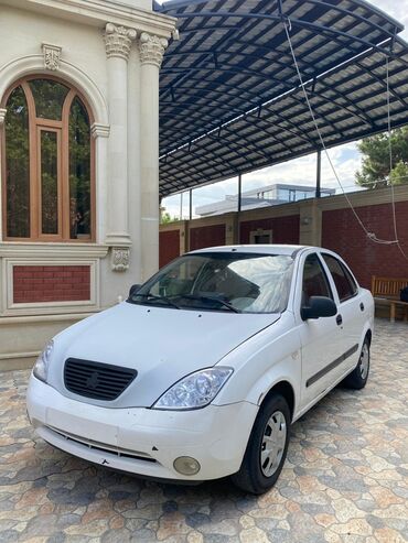 Boşqablar: Ağ rəngli Saipa Saba avtomobili, sedan tipli, dörd qapılı. Avtomobilin