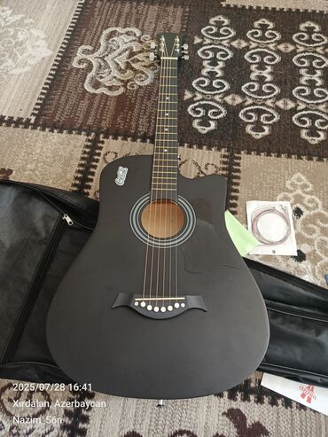 Пианино: Akustik gitara, mat qara rəngdə və kəsilmiş gövdə dizaynı ilə. Bu