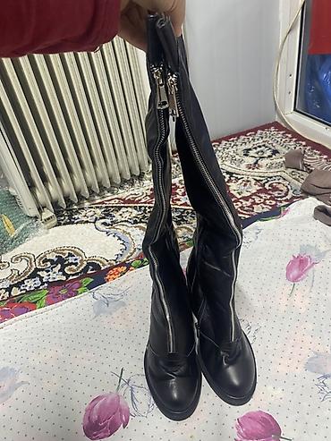 женский пол сапог: Женские высокие сапоги чёрного цвета. Модель выполнена в лаконичном — 4