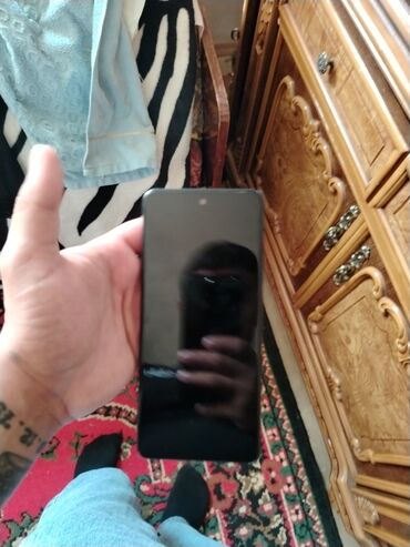 Bu, arxa tərəfində üç kamera modulu olan bir smartfondur. Qara