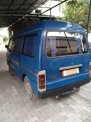 бусик машина: Синий фургон Ford Econovan, оснащенный четырьмя боковыми окнами и
