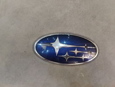 ноздря на капот: Эмблема Subaru (овальная, синий фон с шестью серебристыми звёздами