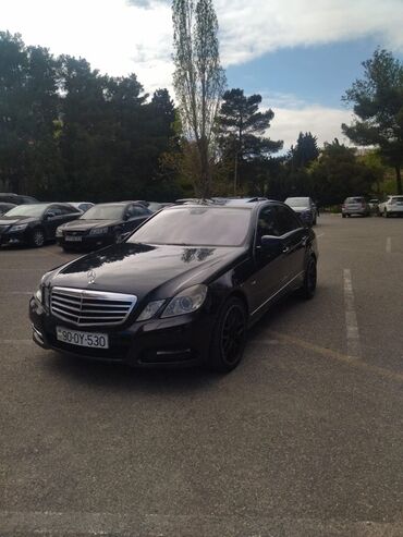 Mercedes-Benz E-Class sedan avtomobili, parlaq qara rəngdə və klassik