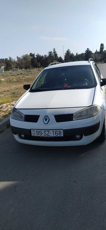 evakuator satılır: Ağ rəngli Renault Megane universal avtomobili. Avtomobilin damında yük
