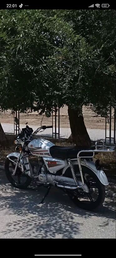 Motonəqliyyatın icarəsi: Ağ rəngdə standart motosiklet, sadə və etibarlı bir nəqliyyat