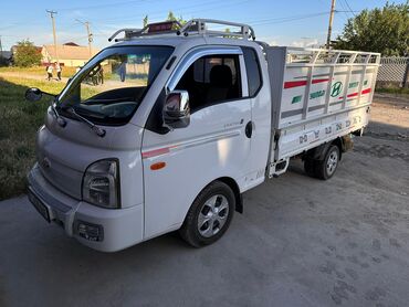 Hyundai: Белый грузовик Hyundai Porter с кузовом. Оборудован дугами на крыше