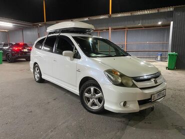 кофр на крышу автомобиля: Белый минивэн Honda Stream с установленным на крыше грузовым боксом