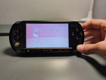 карманный компьютер: Портативная игровая консоль PSP в черном корпусе. Устройство оснащено