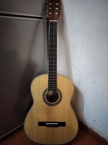Akustik klassik gitara. Açıq rəngli taxtadan hazırlanıb, tünd rəngli