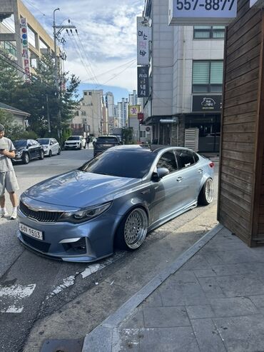 машина кейж: Элегантный седан Kia Optima синего цвета с заниженной посадкой