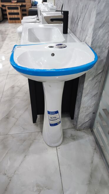 Çanaqlar, tülpanlar: Ayaq üstə dayanan ağ rəngli keramika lavabo, hamam otaqları üçün