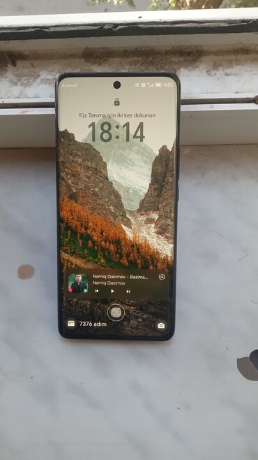 iphone ucun ekran sekilleri: Ön tərəfində mərkəzi kəsikli ekrana malik qara rəngli smartfon