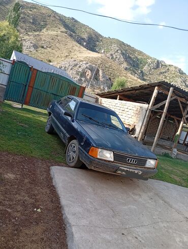 старые машины: Седан Audi 100 C3 в синем цвете, оснащенный четырехдверным кузовом и