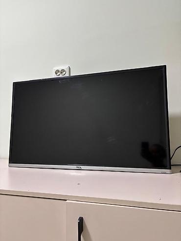 2к монитор: Телевизор TCL, диагональ около 32–40". Тонкая рамка, нижняя планка — 1