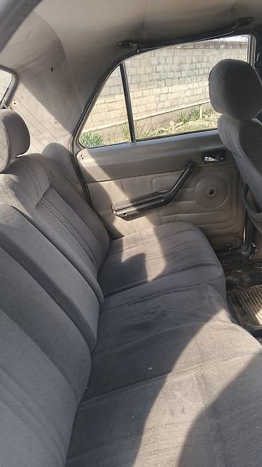 2 qapılı maşın: Ağ rəngli GAZ 3110 sedan avtomobil. Klassik kuzov quruluşuna malik 4 — 7