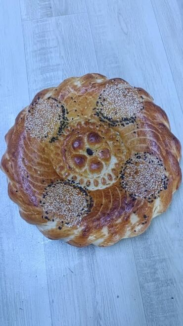 Выпечка, хлебобулочные изделия: Свежеиспеченный узбекский хлеб круглой формы, украшенный характерными — 6