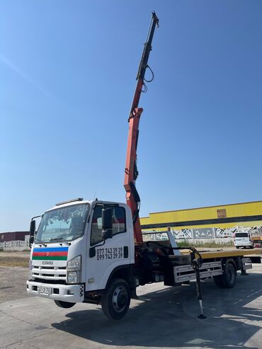 Manipulyatorlar: Yük maşını platforması və hidravlik kranı olan Isuzu modeli. Bu maşın — 4