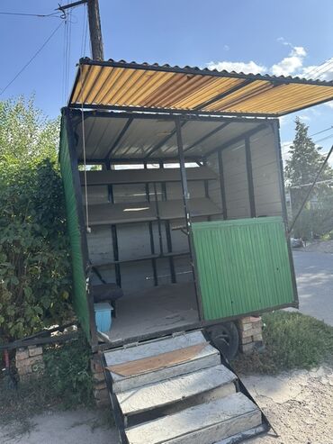 продаю дом с мебелью рабочий городок: Мобильный торговый павильон зеленого цвета, оснащенный откидной крышей
