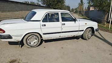 2 qapılı maşın: Ağ rəngli GAZ 3110 sedan avtomobil. Klassik kuzov quruluşuna malik 4 — 3