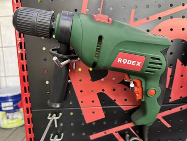 шары металлические: Зеленая электрическая дрель Rodex. Имеет дополнительную рукоятку для