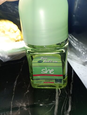Şəffaf şüşə flakonda "She Deo Roll-on" dezodorantı. Yaşıl rəngli
