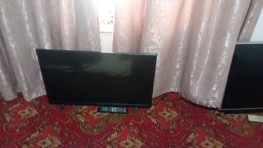 мониторы amd freesync: Черный плоский телевизор с широким экраном, установленный на двух