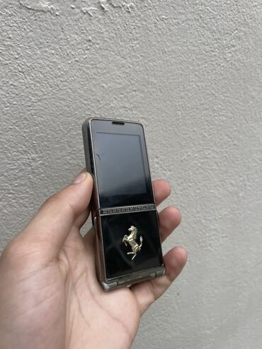duyu bişirən: Ferrari markalı qatlana bilən mobil telefon. Qara rəngli korpusa