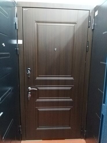 qapi ucun vinil: Qəhvəyi rəngdə, taxta panellərlə bəzədilmiş, möhkəm metal qapı. Qapıda