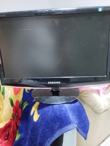 komputer islenmis: Samsung firmasının qara rəngli, dairəvi ayaqlı monitoru. Evdə və ya