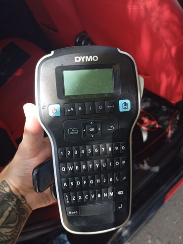 bpyükhəcmli printer: DYMO etiket çap maşını. Bu qara rəngli əl cihazı mətn daxil etmək üçün