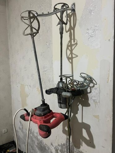 не рабочие инструменты: Ручной строительный миксер красного цвета, предназначенный для