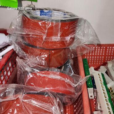 упаковочная лента: Клейкая лента красного цвета. Она упакована в прозрачную пленку, что