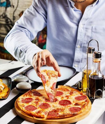Digər qida məhsulları: Taxta altlıqda təqdim olunan, üzəri pepperoni dilimləri ilə
