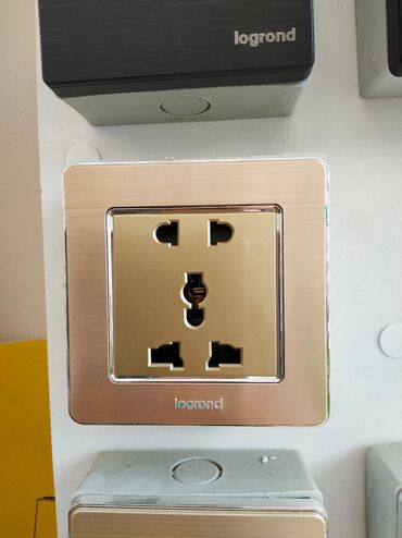 Generatorlar: Legrand şirkətindən qızılı rəngli elektrik rozetkası. Bu rozetka