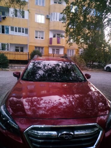 кемпинг дом на колесах: Кроссовер Subaru Outback в темно-красном цвете, оснащенный багажником
