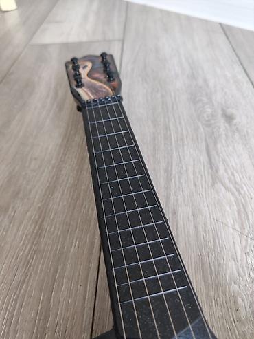 inkişaf etdirici oyuncaqlar: Dekorativ uşaq gitara formasında musiqi aləti. Korpus üzərində — 3