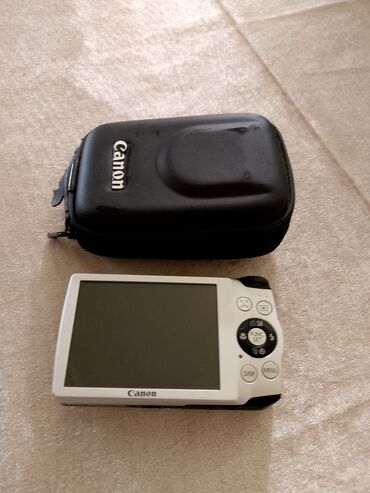 Canon markalı rəqəmsal kamera, açıq rəngli korpusu və qara qoruyucu