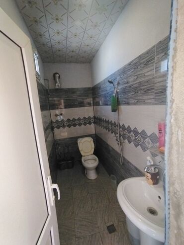hamam ucun ayaq alti: Ağ rəngdə unitaz və umivalnik olan təmiz və səliqəli sanitar qovşağı