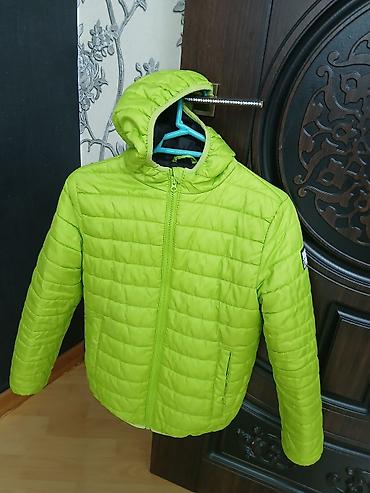 ust geyimleri: Parlaq yaşıl rəngdə, kapüşonlu yüngül gödəkçə. Model ön tərəfdən tam — 1