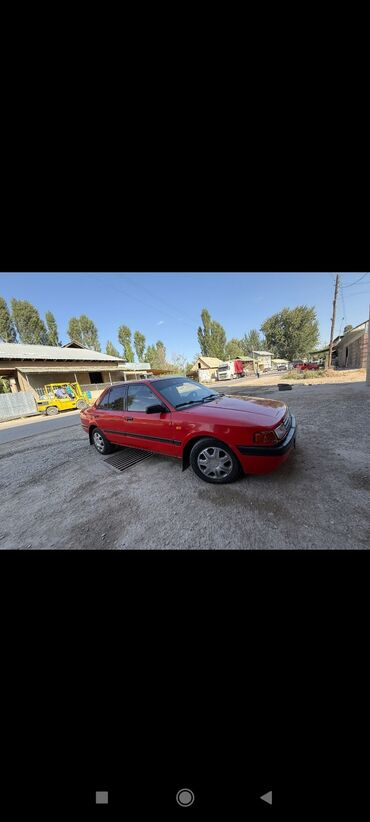 машина купить недорого: Красный седан Mazda 323, оснащенный четырьмя дверями для удобства