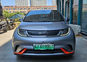 мини электромобиль: Электромобиль BYD Dolphin в сером цвете с ярко-оранжевыми акцентами на