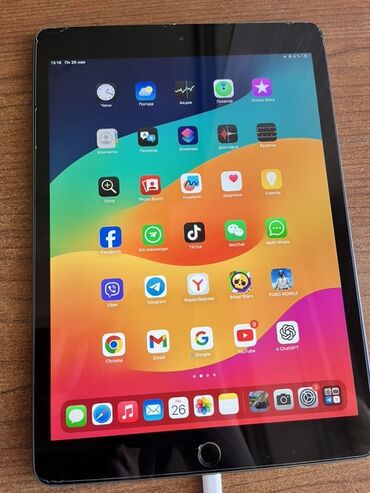 Apple iPad: Qara rəngli Apple iPad planşeti. Planşet müxtəlif proqramlarla dolu