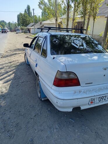 разбор корейский авто: Белый седан Daewoo Nexia с багажником на крыше. Автомобиль оснащен